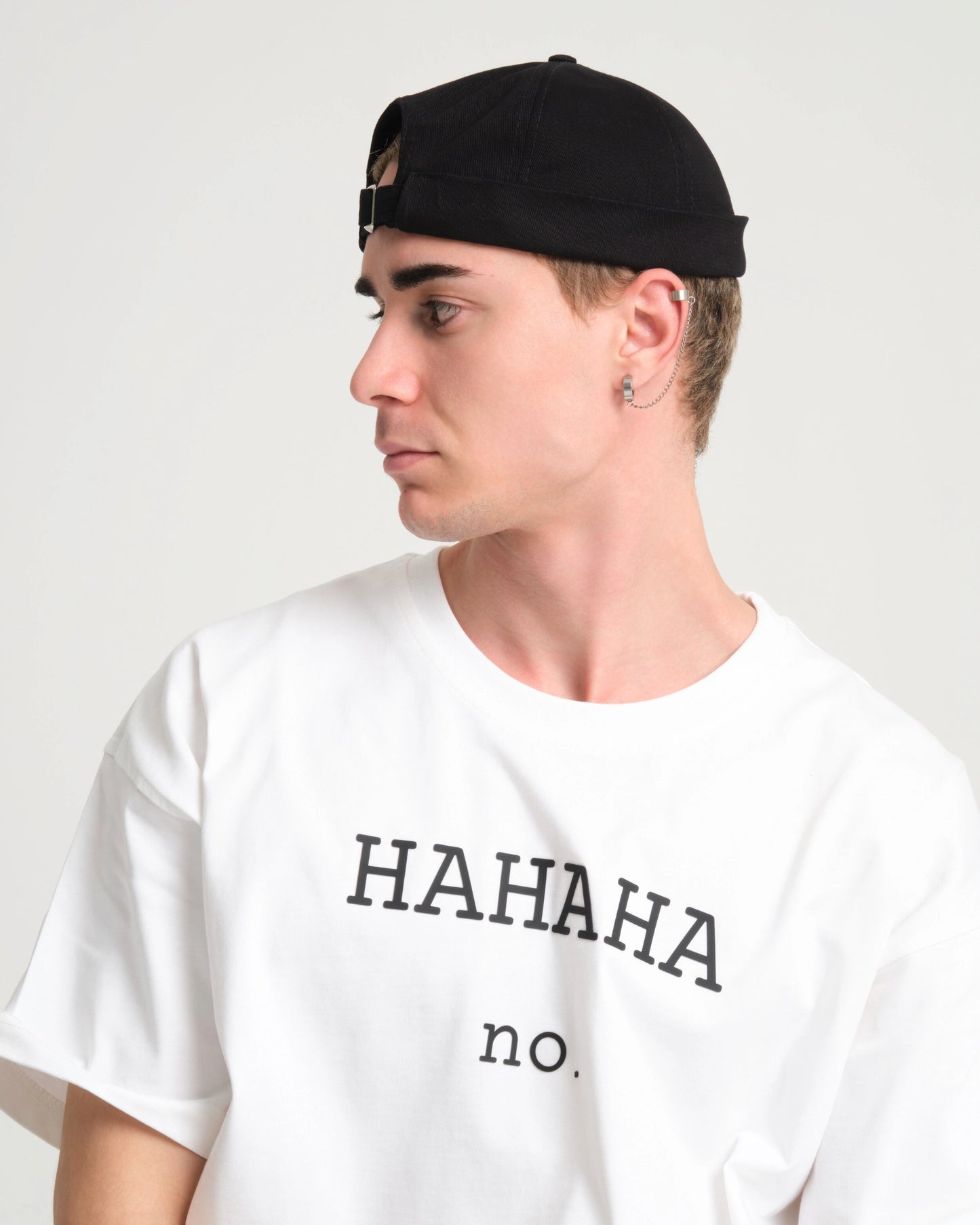 man with white tshirt wearing a black docker cap