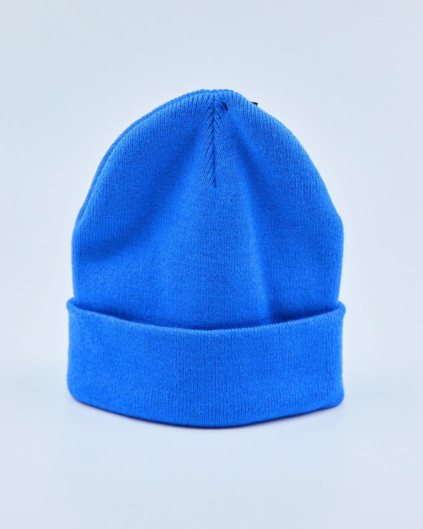 Bright blue beanie on a light gray background