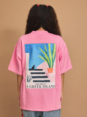 Person wearing a pink t-shirt with a graphic design on the back against a brown background
