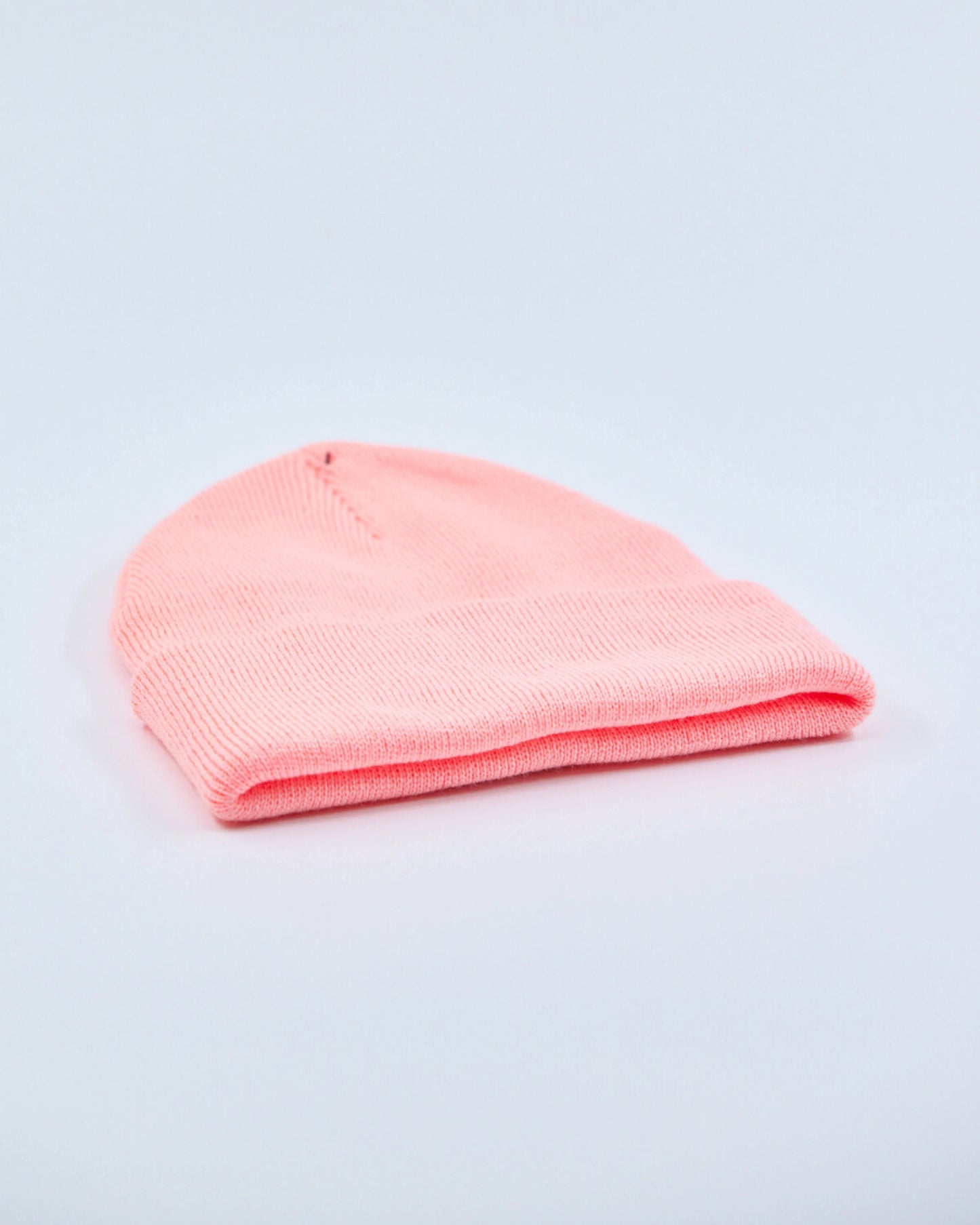 Coral peach beanie on a light gray background