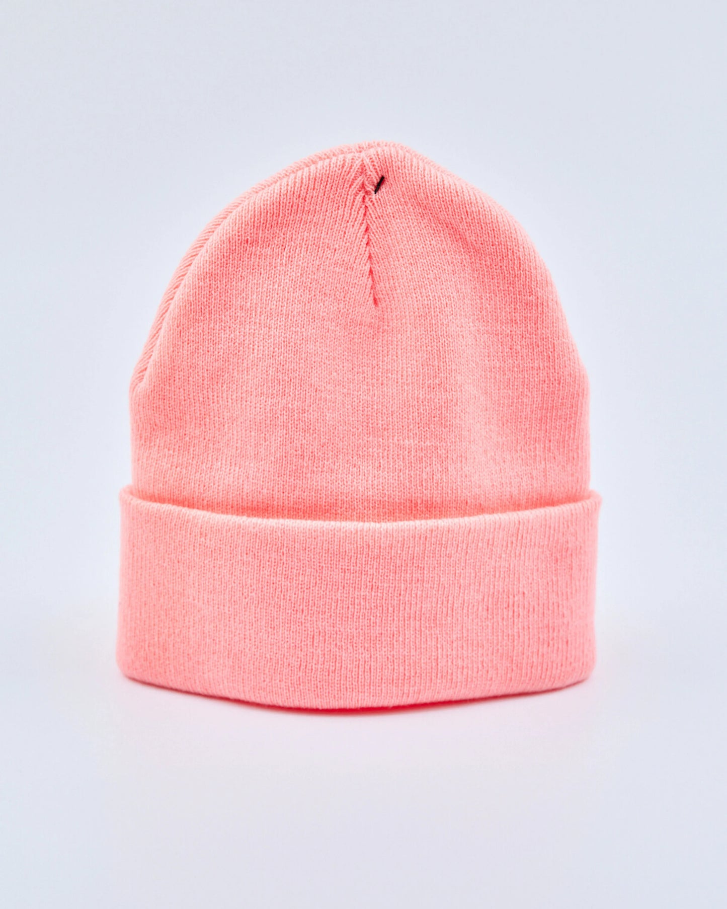 Coral peach beanie on a light gray background