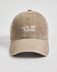Beige cap with 'Cute But Psycho' text on a light gray background