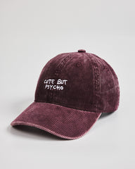 Corduroy cap with 'Cute But Psycho' text on a light gray background