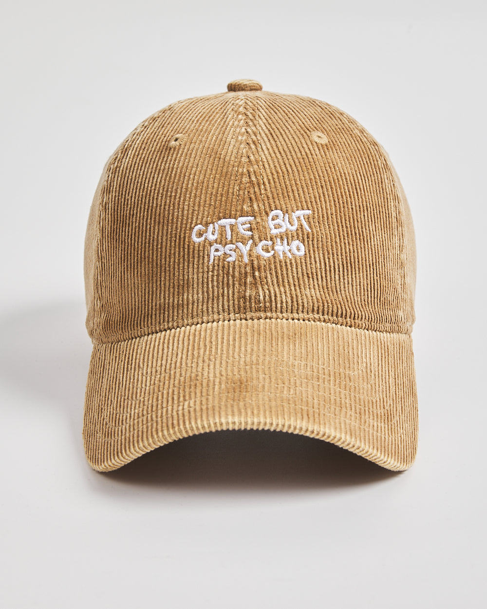 Camel colour cap with 'Cute But Psycho' text on a light gray background