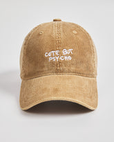 Camel colour cap with 'Cute But Psycho' text on a light gray background