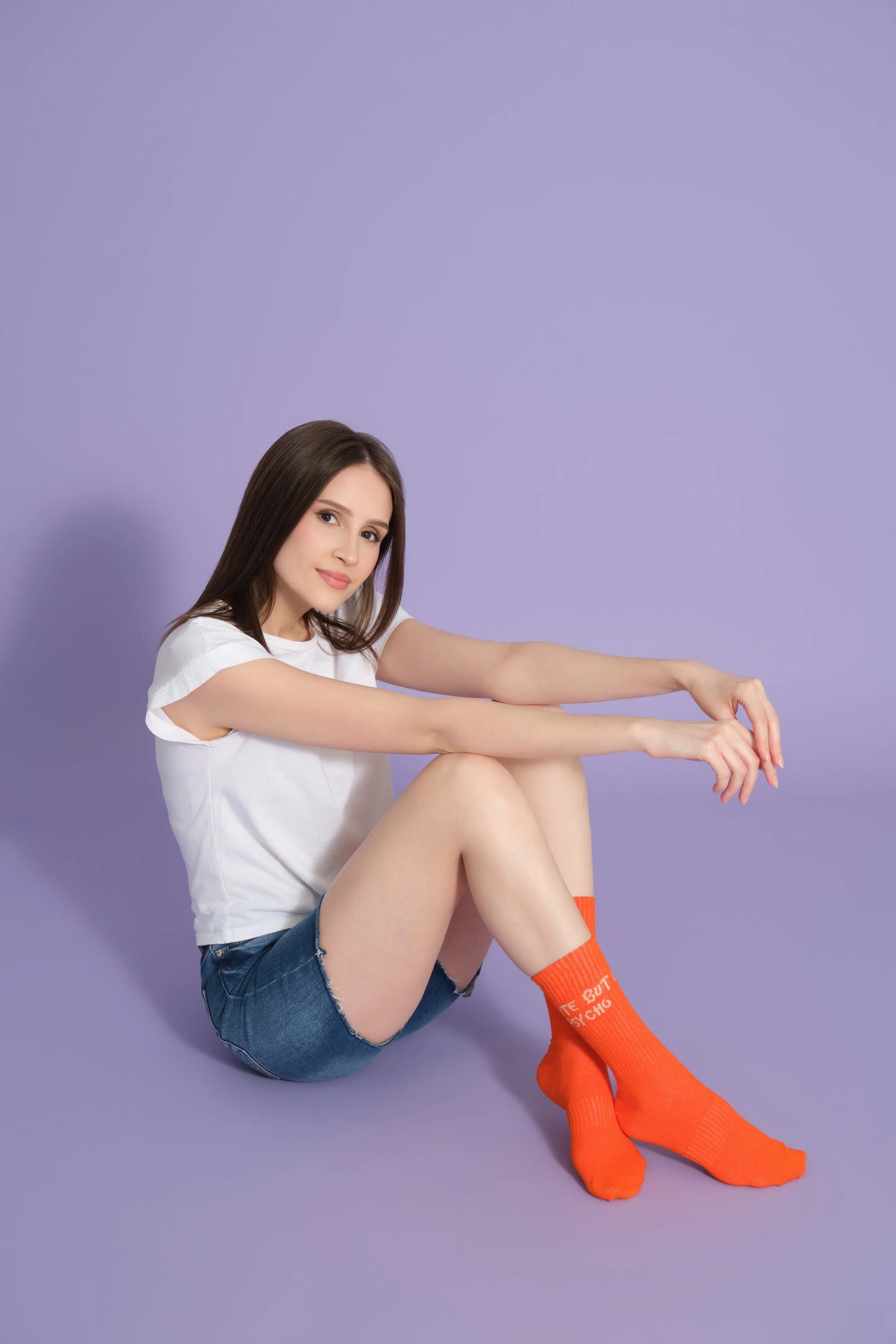 side view of a model wearing orange cute but psycho socks