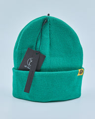 Green beanie with a tag on a light blue background