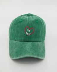 front view of green love myself washed cap