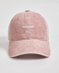 Pink corduroy cap with 'ahaha no.' text on a light gray background