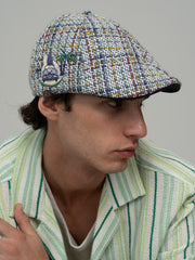 Person wearing Havana White Casket Hat and green striped shirt against a gray background