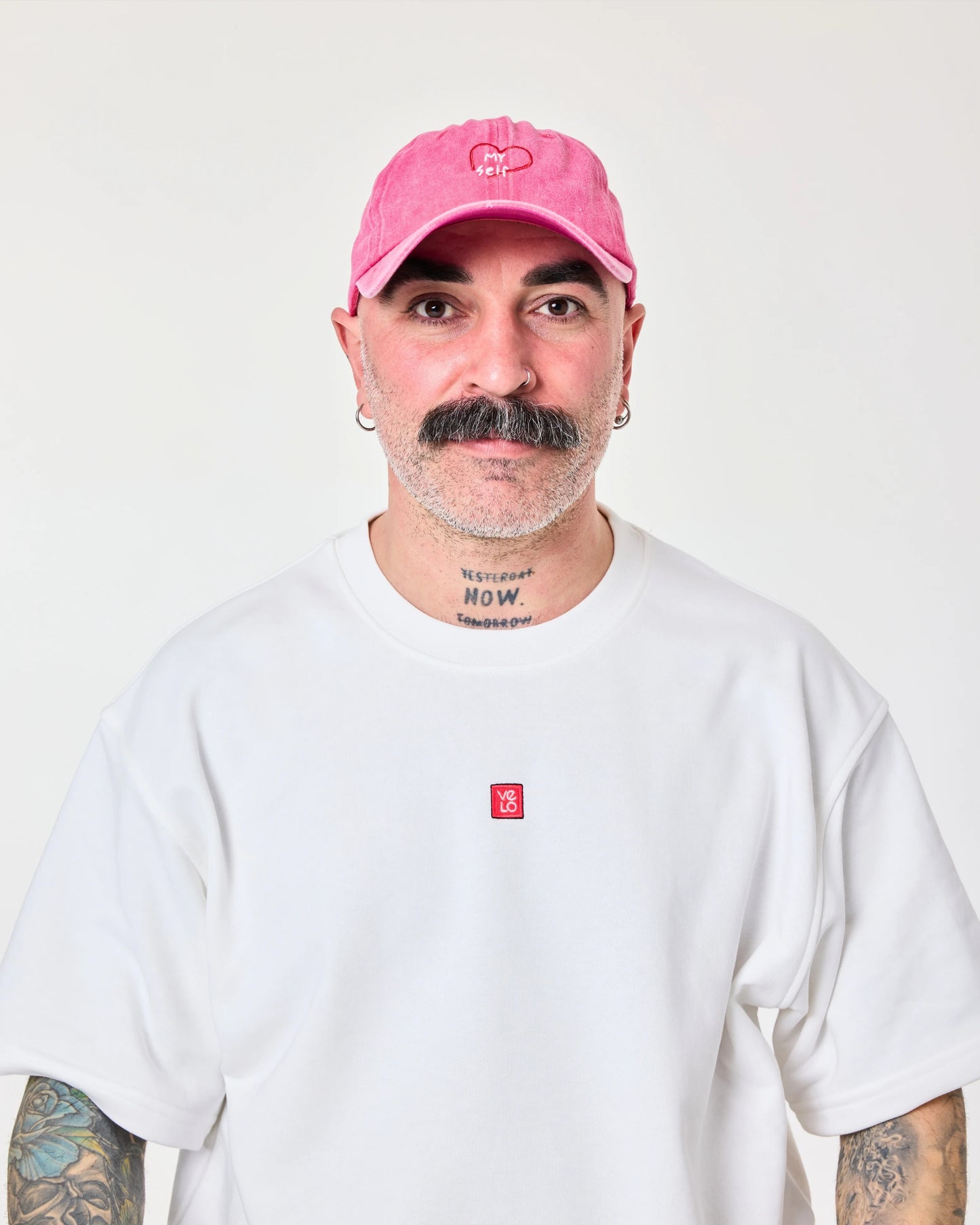 man wearing hot pink washed cap with love myself embroidered in white