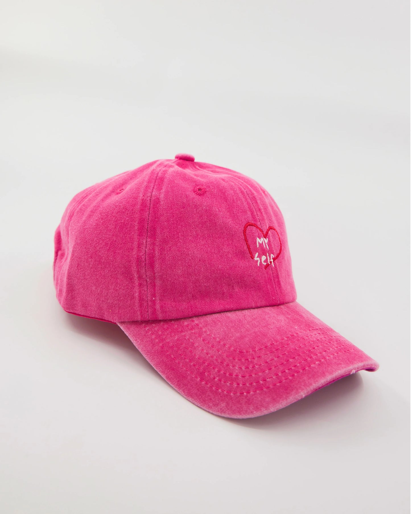 side view of hot pink washed cap with love myself embroidered in white