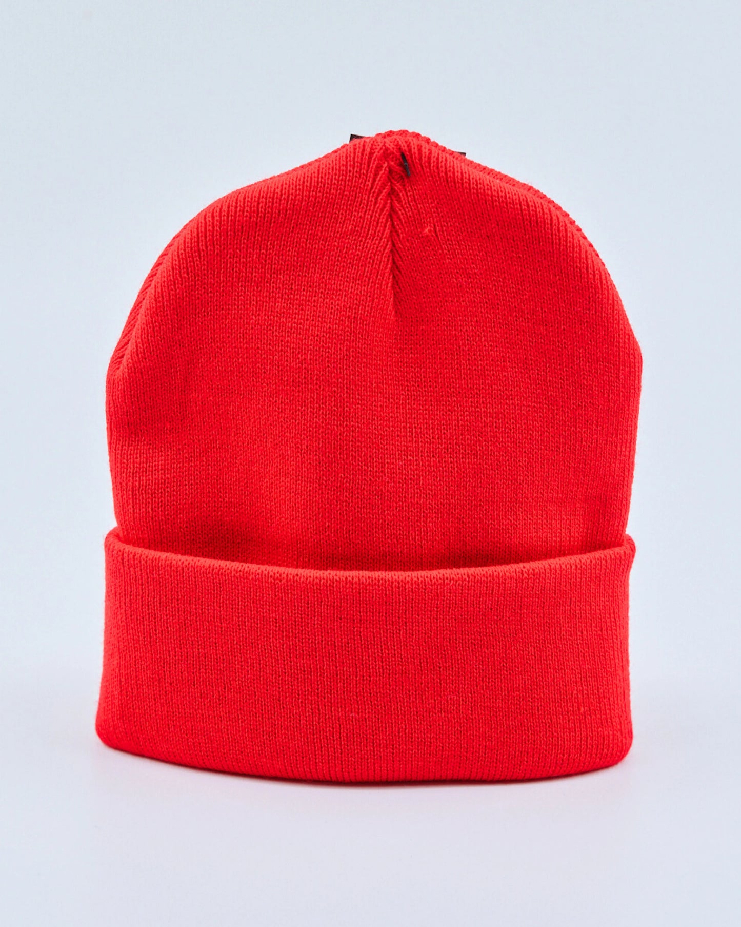Hot red beanie hat on a light gray background