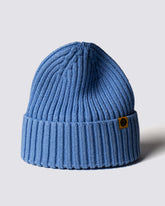 Blue knit beanie with a brand logo on a light gray background