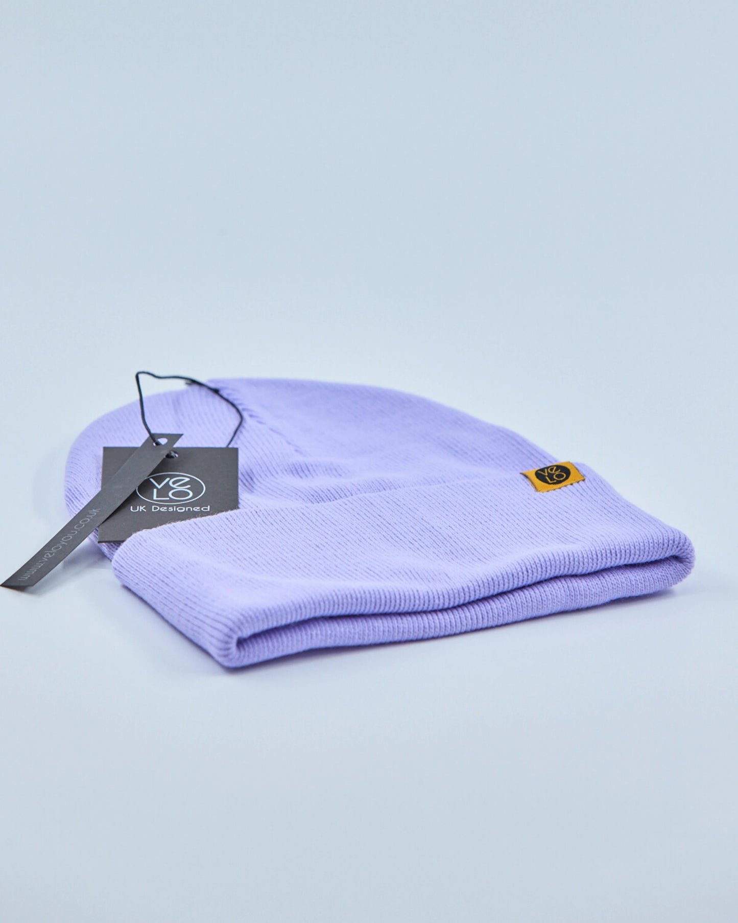Purple beanie with a tag on a light blue background