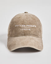 Beige corduroy cap with white text on a light gray background