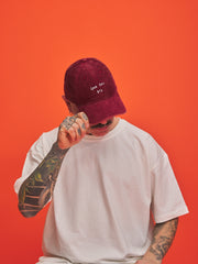 Person wearing a red cap with text on an orange background