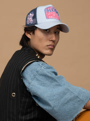 Person wearing Mom Blue Trucker Hat on a beige background