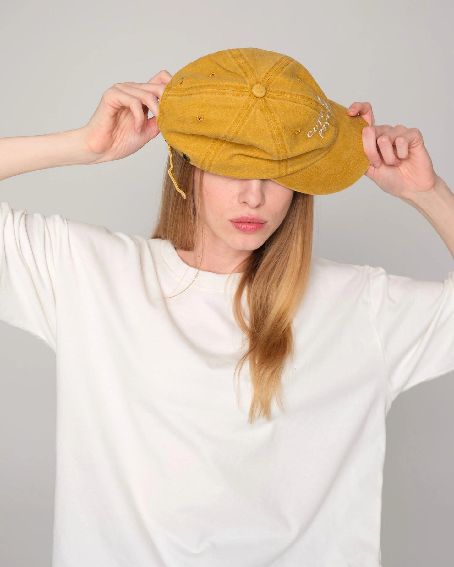 woman wearing Cute But Psycho Mustard Washed Cap Hat