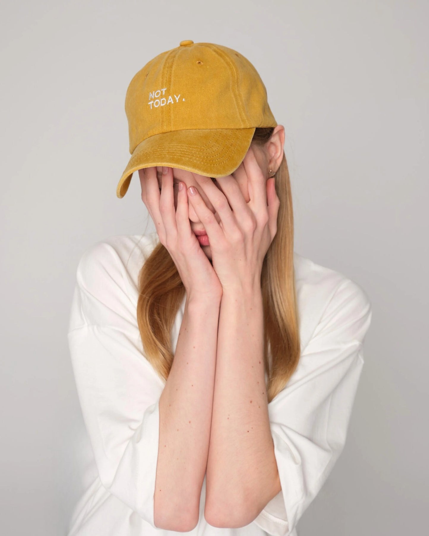 woman wearing Mustard Washed Cap with Not Today embroidered in white