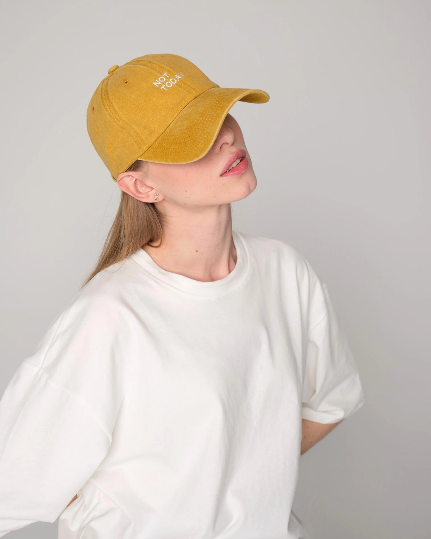 woman wearing Mustard Washed Cap with Not Today embroidered in white