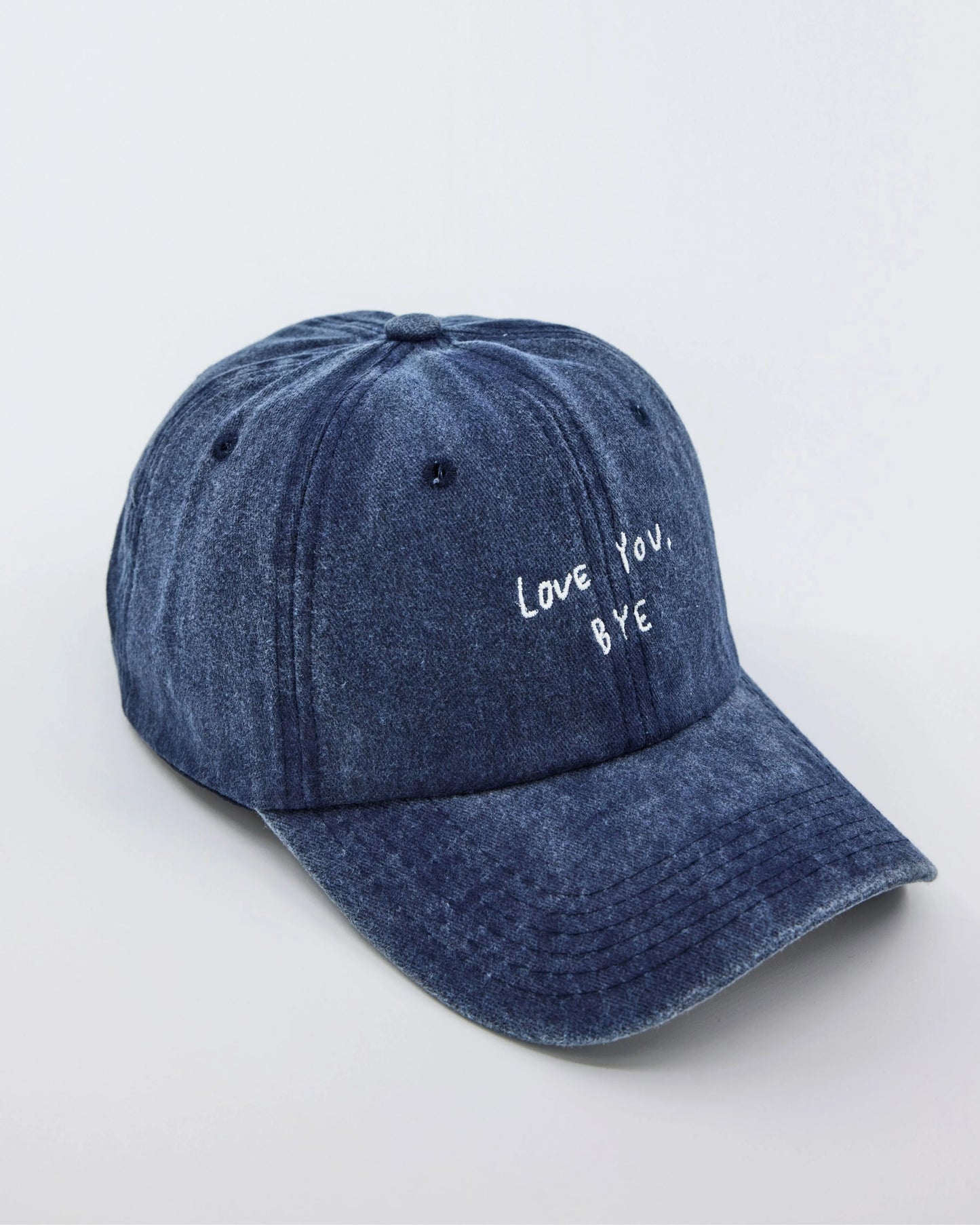 side view of Navy Blue Washed Cap with Love You Bye embroidered in white