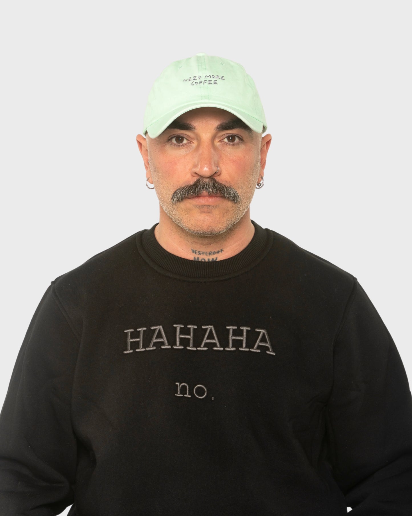 A man wearing the Need More Coffee Light Green Washed Cap