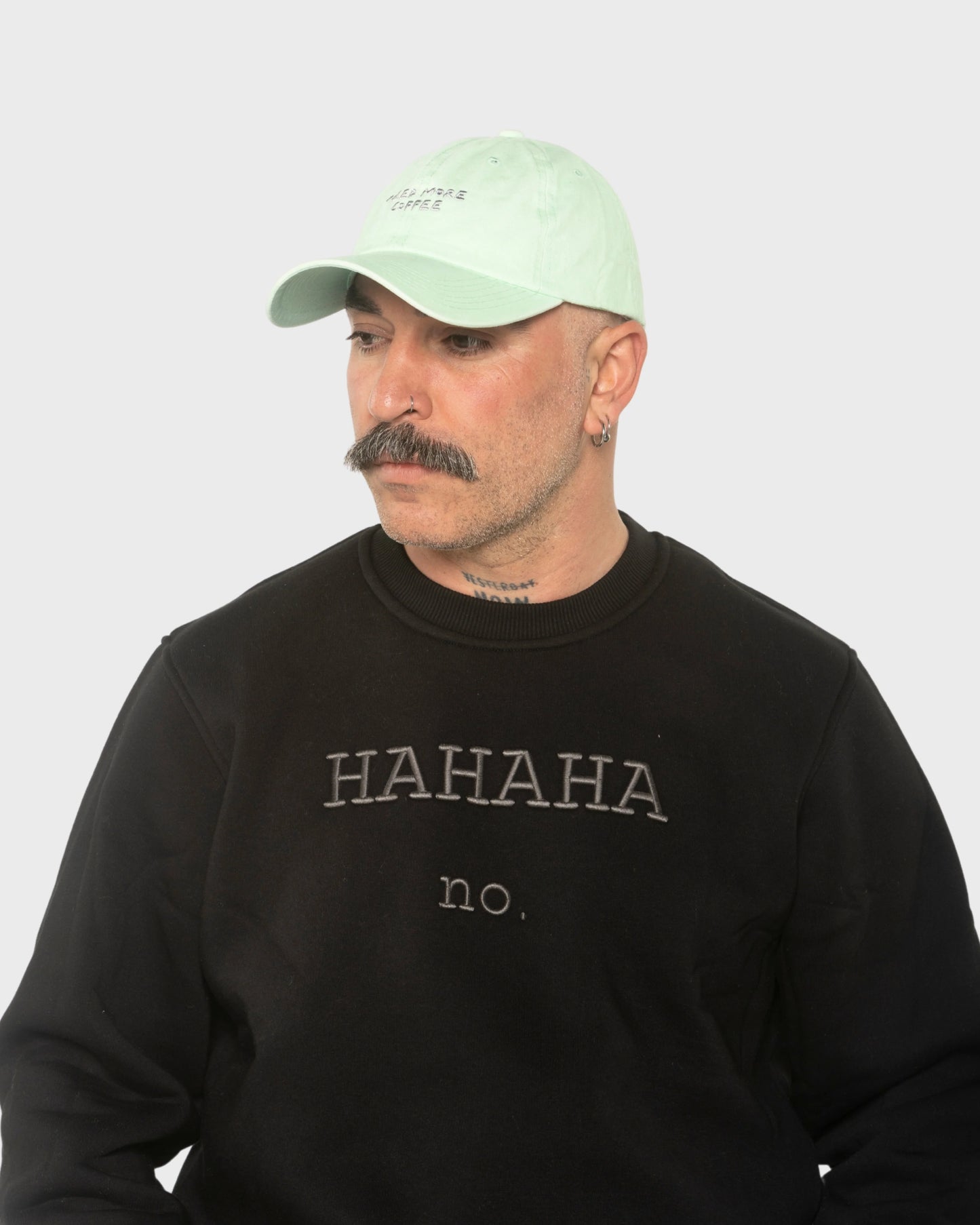 A man wearing the Need More Coffee Light Green Washed Cap