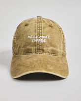 Brown cap with 'NEED MORE COFFEE' text on a light gray background
