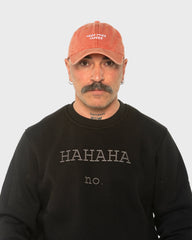A man wearing the Need More Coffee Orange Washed Cap