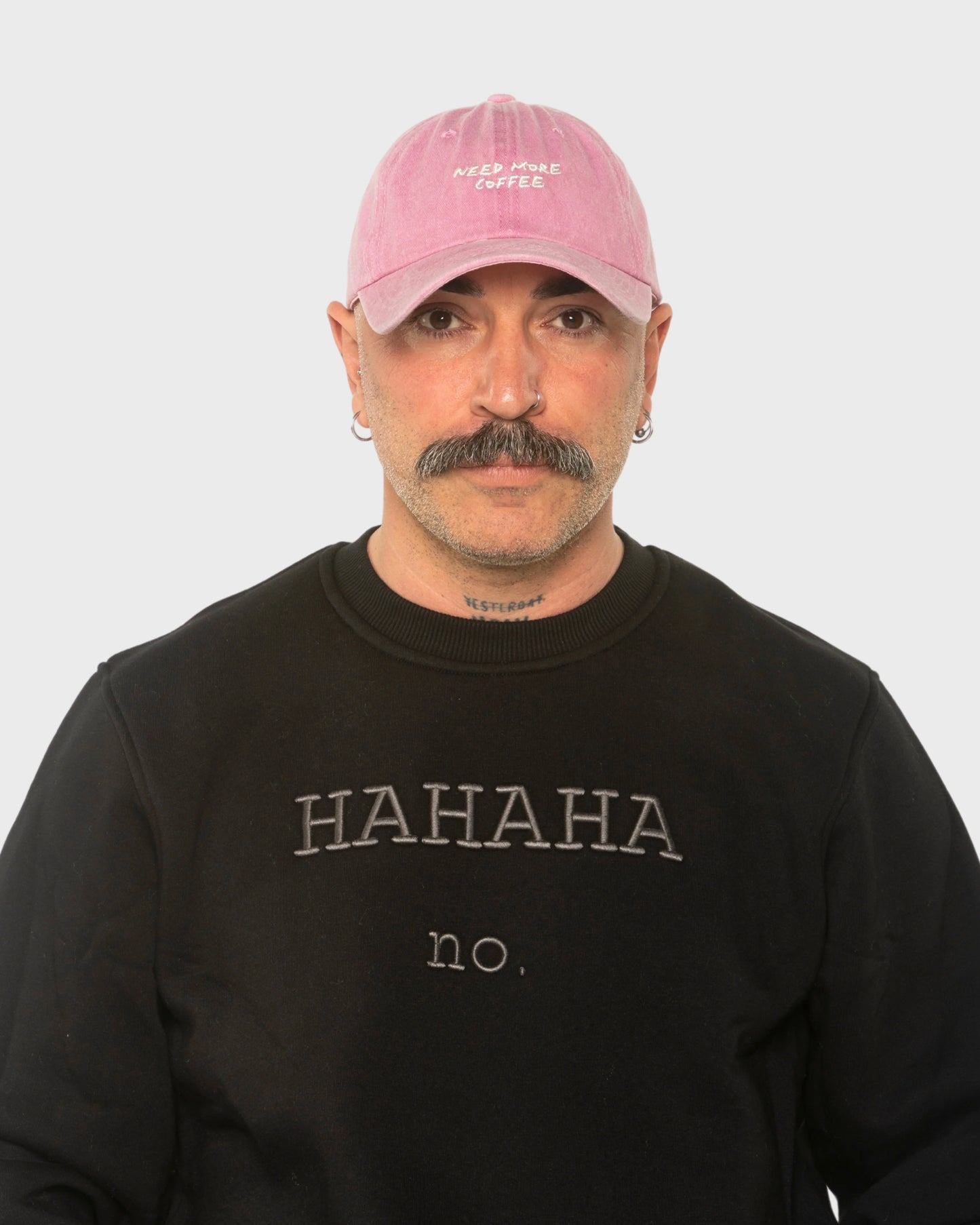 A man wearing the Need More Coffee Pink Washed Cap