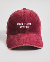 Red cap with 'NEED MORE COFFEE' text on a light gray background