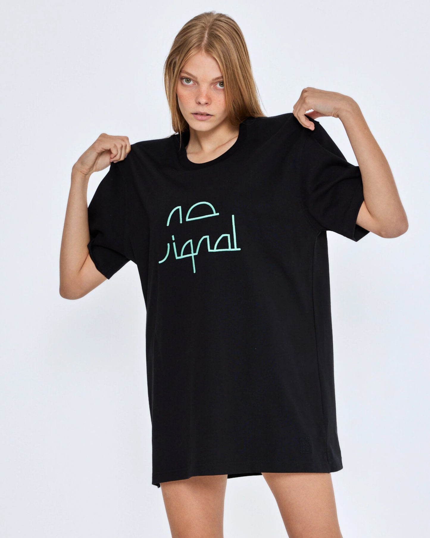 Person wearing a black t-shirt with green text on a white background