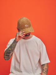 Person wearing a camel cap with 'Not Today' text on an orange background