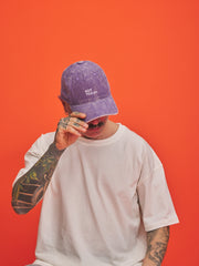 Person wearing a purple cap with 'Not Today' text on an orange background