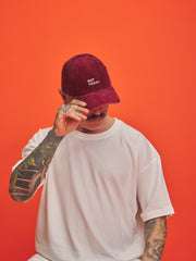 Person wearing a maroon cap with 'Not Today' text on an orange background