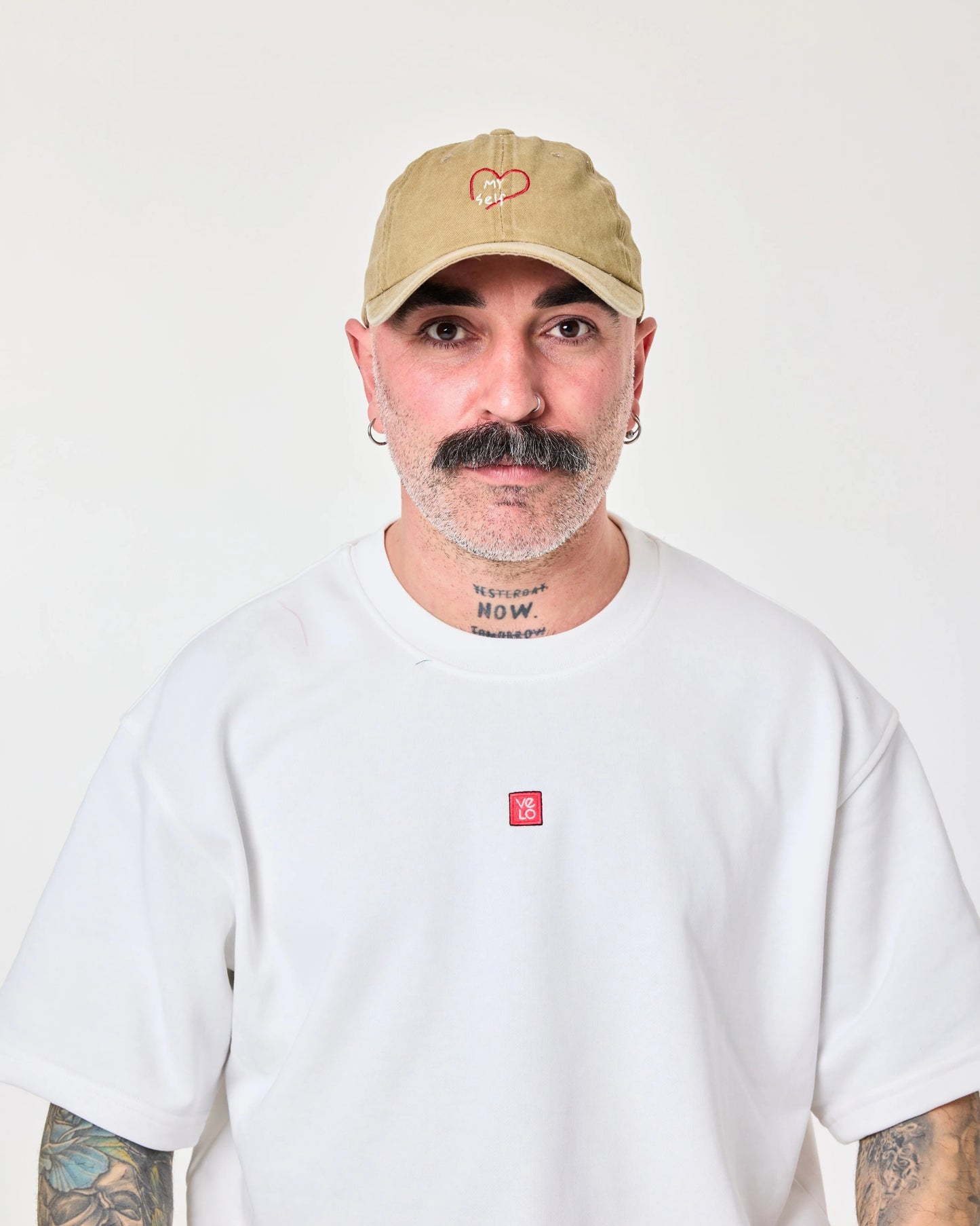 man wearing olive green washed cap with love myself embroidered in white