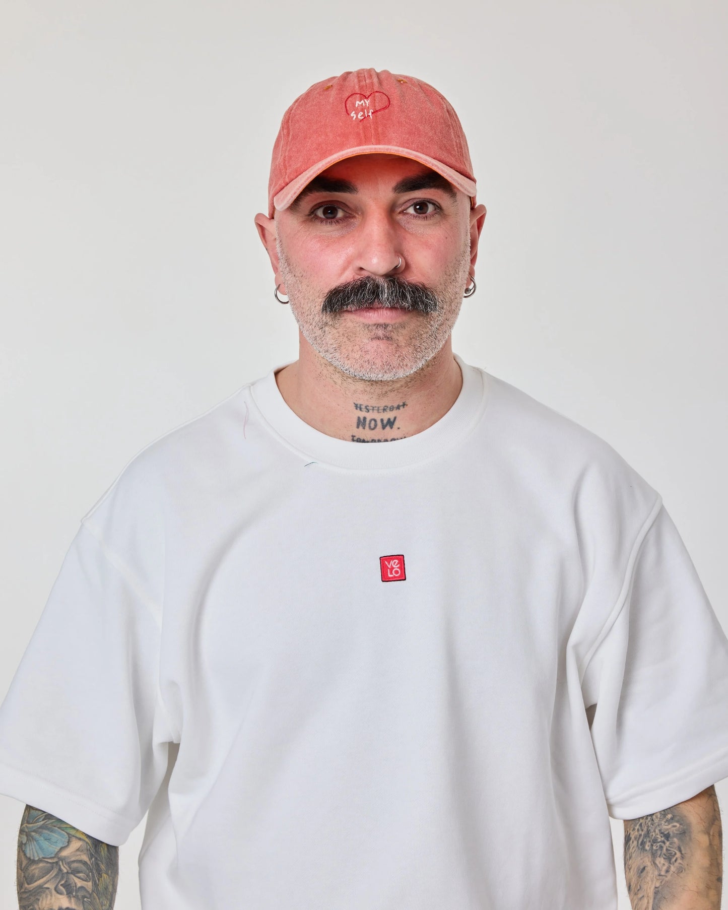 man wearing Orange Washed Cap with Love Myself embroidered in white