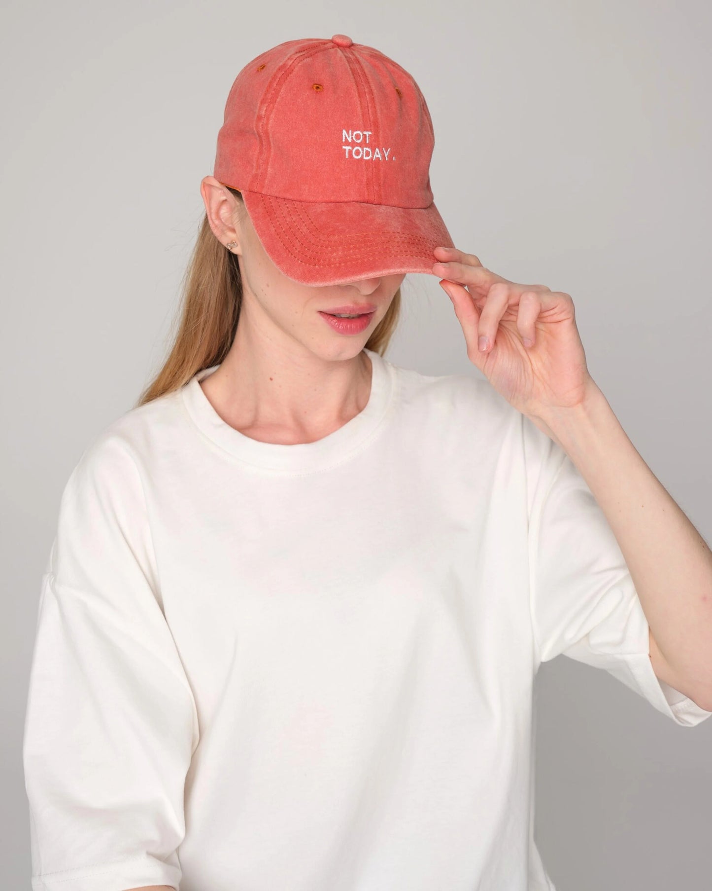 woman holding Orange Washed Cap with Not Today embroidered in white
