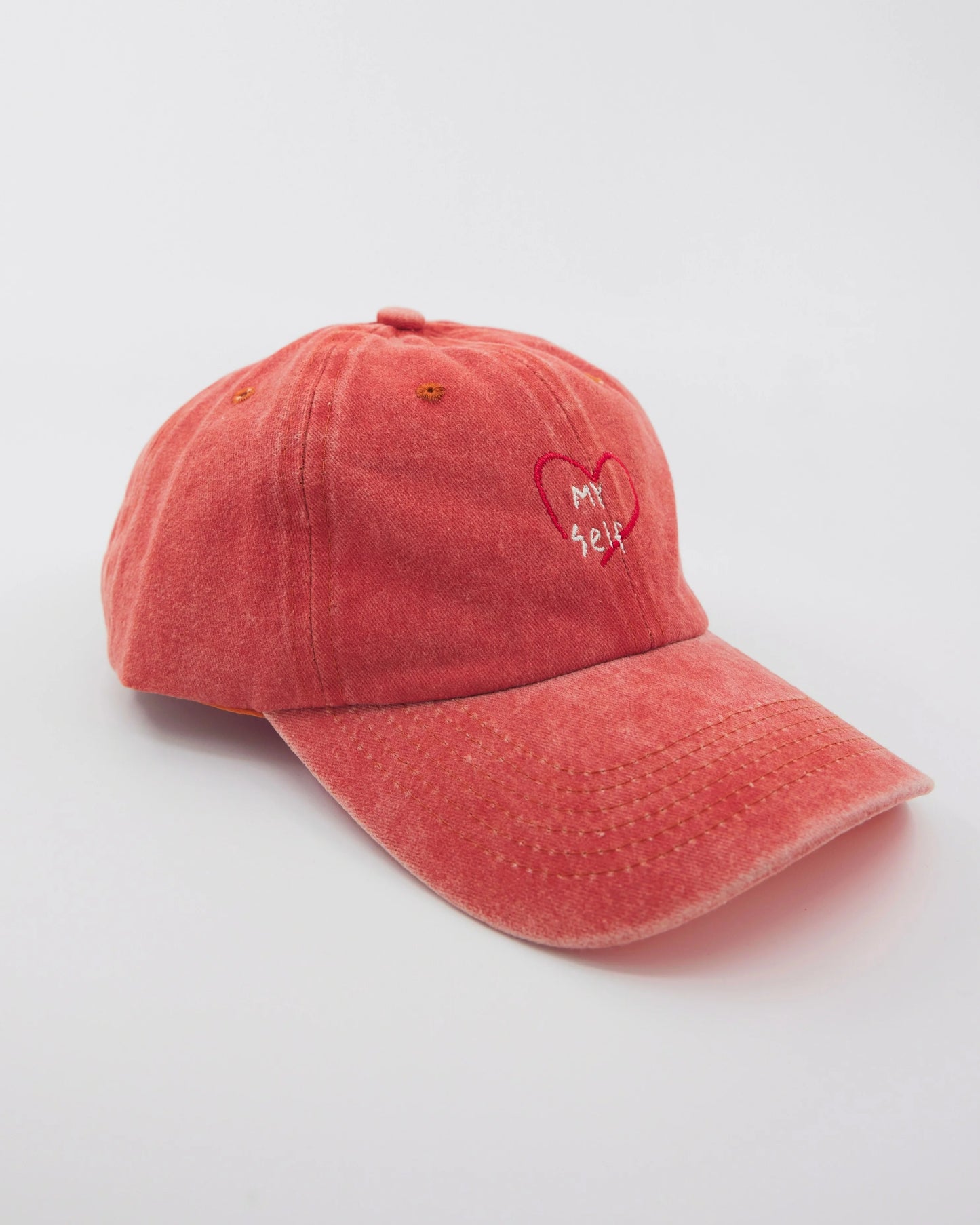 side view of Orange Washed Cap with Love Myself embroidered in white