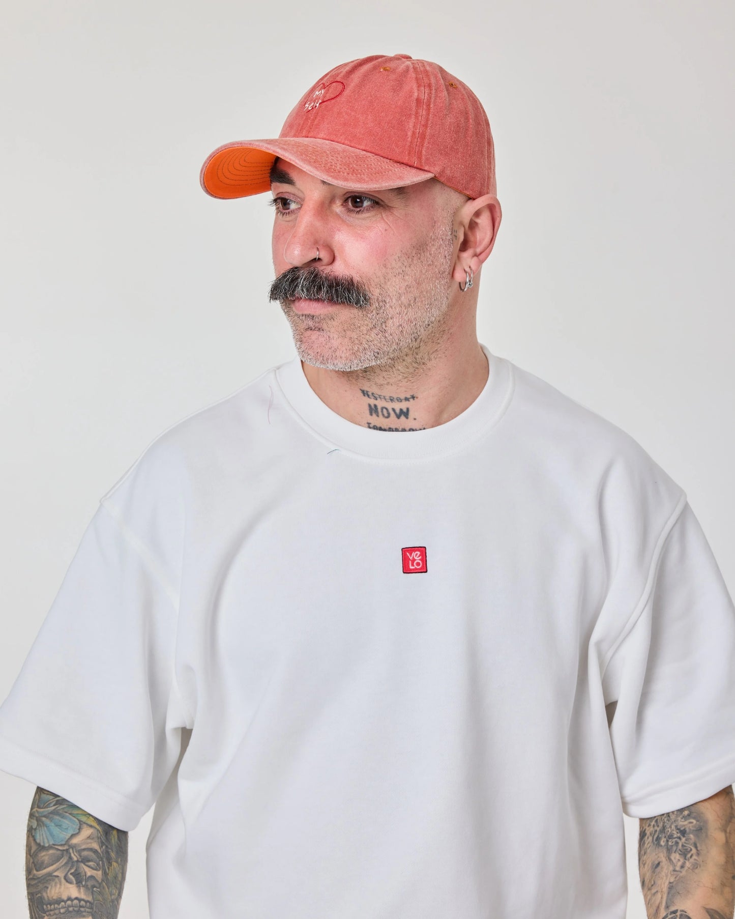 man wearing Orange Washed Cap with Love Myself embroidered in white