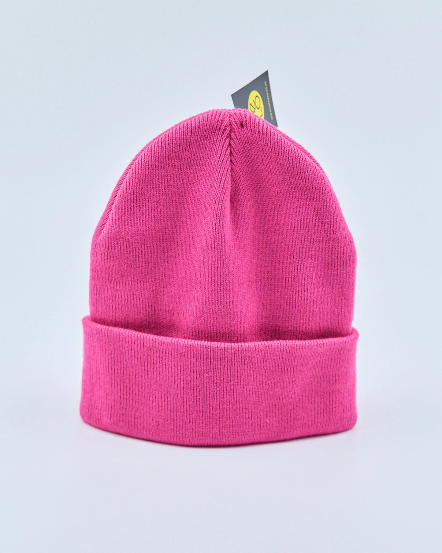 Pink beanie with a brand tag on a light gray background