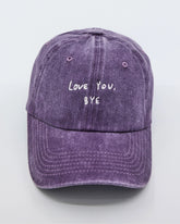 front view of a purple washed cap with 'Love You, Bye' embroidered in white.