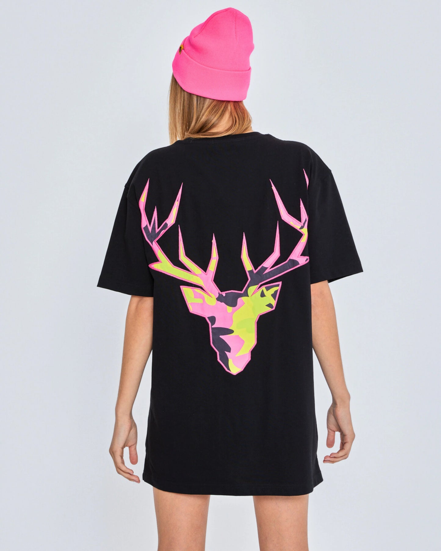 Person wearing a black t-shirt with a colorful deer design on the back, against a plain background.