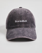 Gray corduroy cap with 'Shoreditch' text on a light gray background
