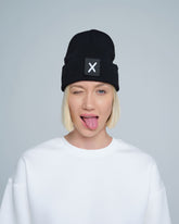 women wearing black beanie with X letter patch on it