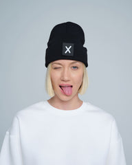 women wearing black beanie with X letter patch on it
