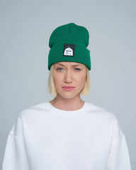 female model wearing dark green beanie with a 'duck' patch on the front