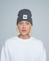women model wearing dark grey patch ready beanie with 'N' letter patch on the front