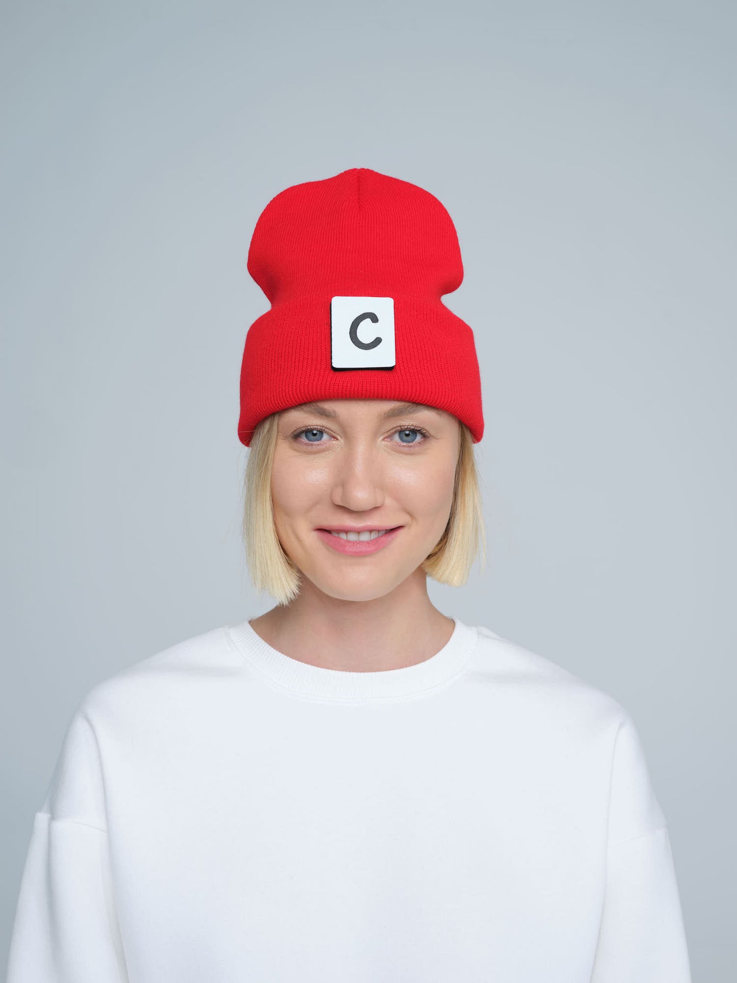 women wearing hot red beanie with 'C' letter patch on it
